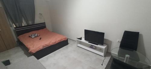 Kleines Zimmer mit einem kleinen Bett und einem TV. in der Unterkunft Amazing Studio 10 minutes walk To Center no1 in Thessaloniki