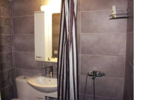 ein Badezimmer mit einem Waschbecken, einem WC und einem Spiegel in der Unterkunft Amazing Studio 10 minutes walk To Center no1 in Thessaloniki
