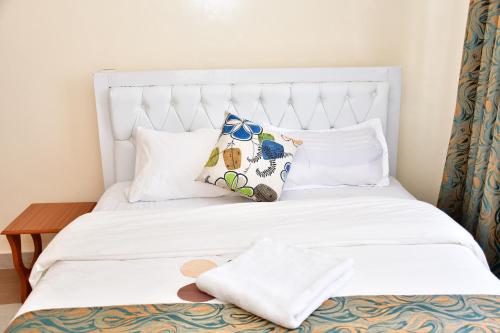 Una cama blanca con dos almohadas. en Hope Comfort homes, en Nairobi