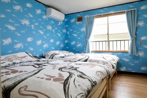 1 Schlafzimmer mit 2 Betten und blauen Wänden in der Unterkunft Kotoni / Vacation STAY 4930 in Sapporo