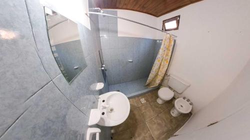 uma casa de banho com um chuveiro, um WC e um lavatório. em Hotel One 