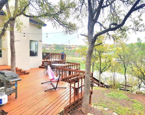 a wooden deck with a table and chairs on a house at A Rare Find! - Bright & Gorgeous Lake Home in Marble Falls in Marble Falls