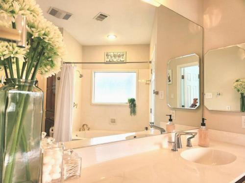 a bathroom with a sink and a vase of flowers at A Rare Find! - Bright & Gorgeous Lake Home in Marble Falls in Marble Falls