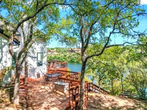 a house with a large deck with trees at A Rare Find! - Bright & Gorgeous Lake Home in Marble Falls in Marble Falls