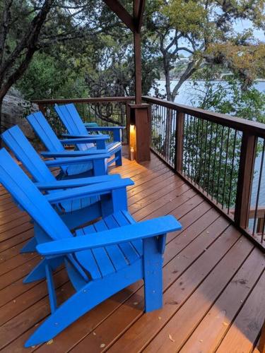 three blue chairs sitting on a wooden deck at A Rare Find! - Bright & Gorgeous Lake Home in Marble Falls in Marble Falls