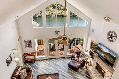 a living room with a vaulted ceiling with a large window at A Rare Find! - Bright & Gorgeous Lake Home in Marble Falls in Marble Falls
