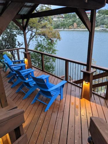 four blue chairs sitting on a deck near the water at A Rare Find! - Bright & Gorgeous Lake Home in Marble Falls in Marble Falls