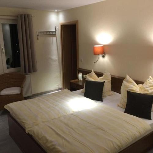 una camera d'albergo con un grande letto bianco con cuscini di Hotel Loky a Bandung