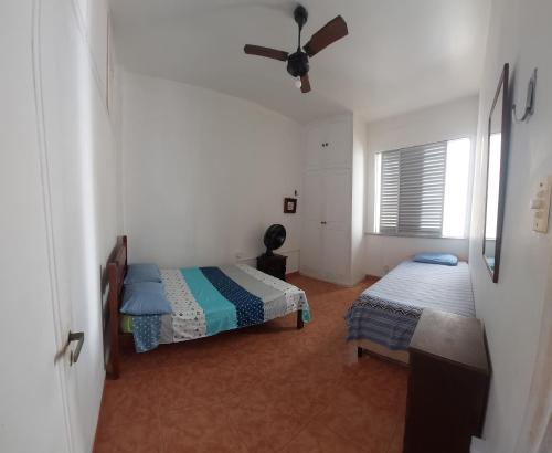 um quarto com 2 camas e uma ventoinha de tecto em QUARTO EM COPACABANA no Rio de Janeiro