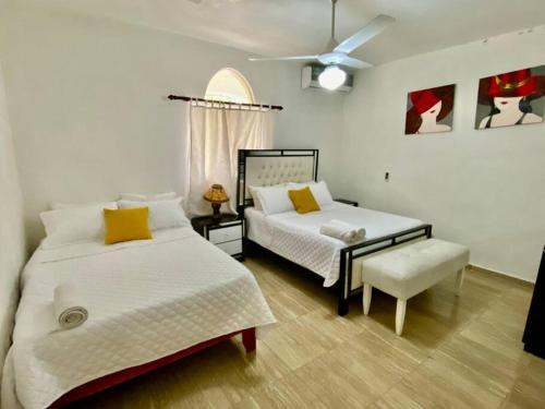 - une chambre avec 2 lits et un ventilateur de plafond dans l'établissement Casa Tipo Villa, Piscina, Playas De RSJ a 4 min, à Río San Juan