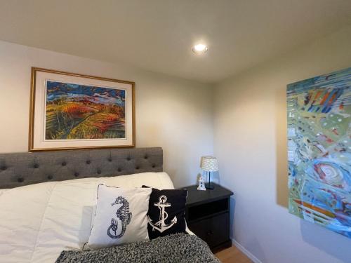 a bedroom with a bed and a painting on the wall at Skyview Apartment at Otter Point in Sooke