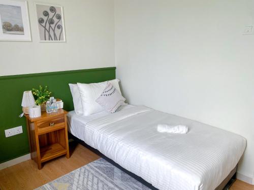 a bedroom with a bed and a night stand at 5BR5B in Skudai, 15mins to UTM&Sutera, 7-16pax, WiFi in Skudai