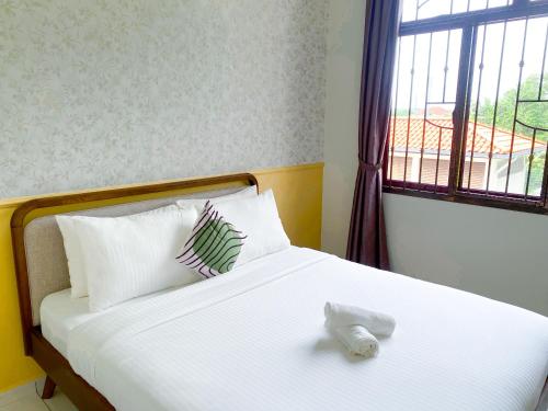a bedroom with a bed with two pillows and a window at 5BR5B in Skudai, 15mins to UTM&Sutera, 7-16pax, WiFi in Skudai