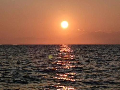 a sunset over the ocean with the sun in the sky at Homatino Eco Smart in Nea Moudania