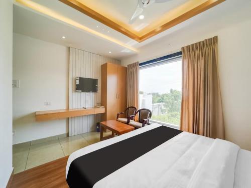 um quarto de hotel com uma cama, uma secretária e uma janela em Hotel Lotus Blue By De Tulip em Bhopal