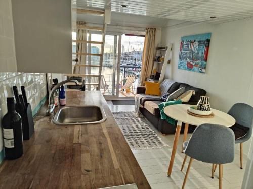 eine Küche und ein Wohnzimmer mit einem Sofa und einem Tisch in der Unterkunft Tiny float home Brighton in Brighton & Hove