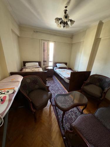 a room with three beds and a table and chairs at Charming Downtown Apartment in Alexandria