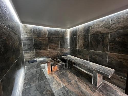 baño con banco en una pared de azulejos en Hotel Restaurante Versalles, en Melgar