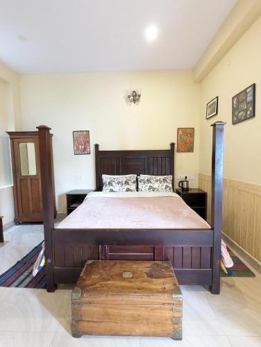 a bedroom with a large bed with a wooden frame at Cloudwalks Homestay in Kodaikānāl