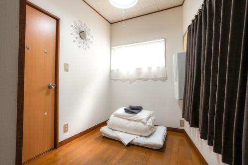 a room with white towels on a wooden floor at Budget 3-Bedrooms Villa#4mins to Ikebukuro#Hight speed wifi#Near Train Tracks in Tokyo