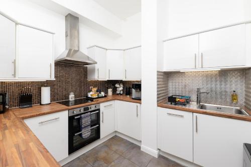 a kitchen with white cabinets and a sink at Old Edinburgh Court in Inverness