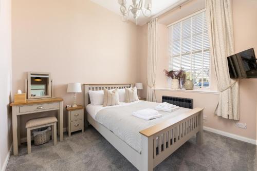 um quarto com uma cama, uma televisão e uma janela em 1 Old Edinburgh Court em Inverness