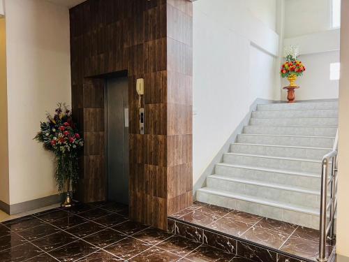 a staircase in a building with flowers on the wall at Pilatus Apartment in Loei