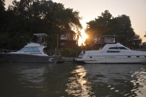 two boats are docked in the water with the sunset at ayutthaya river camp and yacht charter in Ban Khlong Suan Phlu