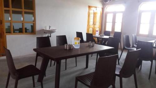 a dining room with a wooden table and chairs at Al-Bilad Guest House in Srinagar