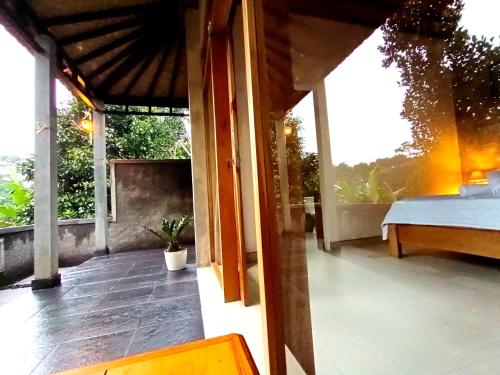a balcony of a house with a view of the yard at Artomoro Bali in Munduk