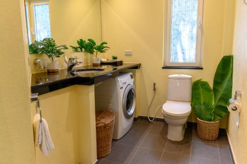 a bathroom with a washing machine and a washer at Bikini Villas Koh Chang in Ko Chang