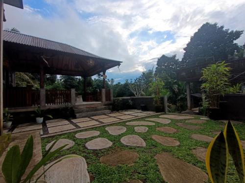a garden with rocks on the grass in front of a building at Artomoro Bali in Munduk