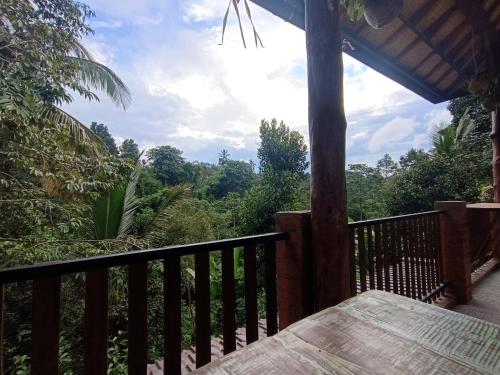 a balcony with a table and a view of the forest at Artomoro Bali in Munduk
