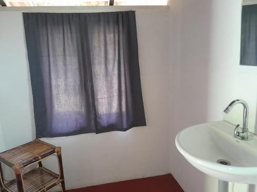 a bathroom with a sink and a tub and a window at Tranquilandia in Varagampadi