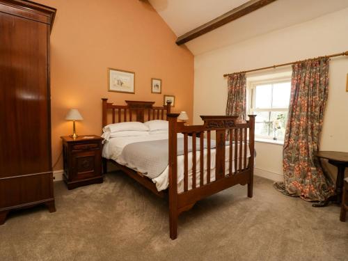 un dormitorio con una cama y una ventana en Moss Side Farm Cottage, en lower hawthwaite