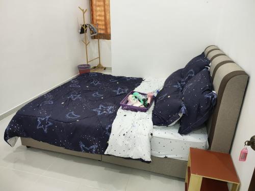a bed with a blue comforter and pillows at ankang in Alor Setar