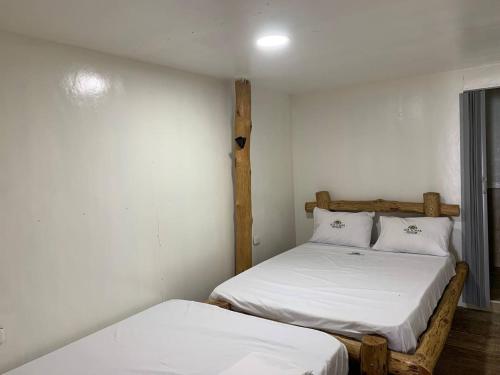 duas camas num pequeno quarto com lençóis brancos em Venido Del Mar. Neymar em Barú