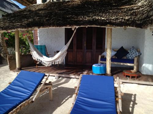 a porch of a house with two chairs and a hammock at Mamamapambo Boutique Hotel in Jambiani