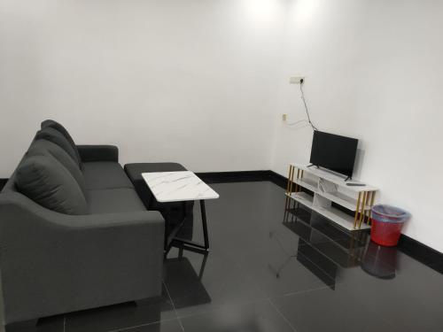 sala de estar con sofá y mesa con TV en ankang, en Alor Setar