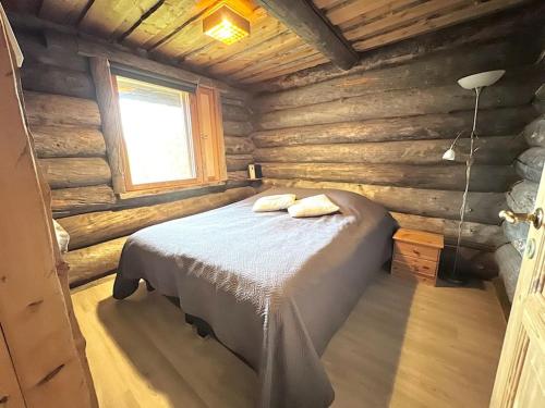 a bedroom with a bed in a log cabin at Keloparitalon loma-asunto Ylläs-näkymällä ja paljulla in Ylläsjärvi