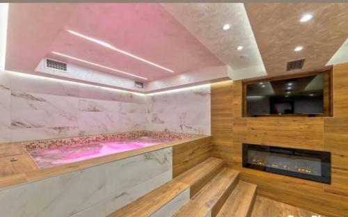 a spa room with a hot tub and a tv at Vila Pino Silvestre in Zlatibor