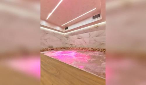 a bathroom with a hot tub with pink water at Vila Pino Silvestre in Zlatibor