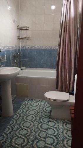 een badkamer met een bad, een toilet en een wastafel bij Horizon in Bisjkek