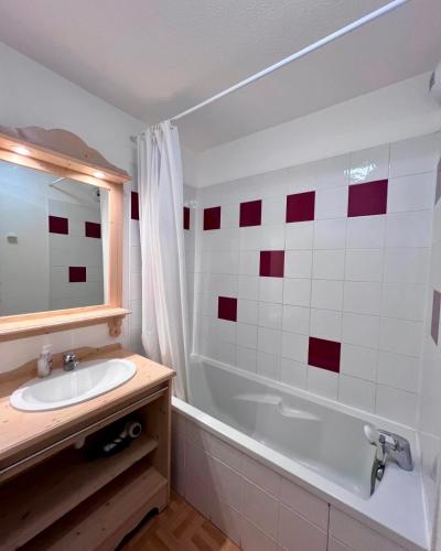 une salle de bain avec un lavabo et une baignoire dans l'établissement Appartement 4 personnes avec piscine intérieure, à Puy-Saint-Vincent