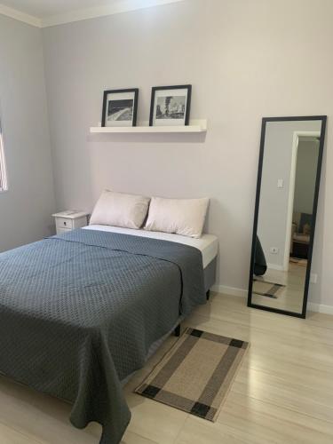 um quarto com uma cama e um espelho em Apartamento em Santos na Ponta da Praia em Santos