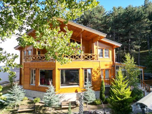 a log home with a large porch and large windows at Amorium Hotel in Kastamonu