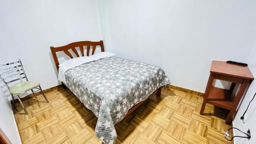 滁林的住宿－Hostal príncipe，卧室配有1张床、1张桌子和1把椅子