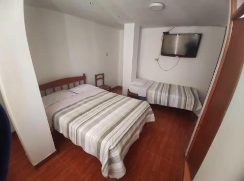 滁林的住宿－Hostal príncipe，卧室配有一张床,墙上配有电视。
