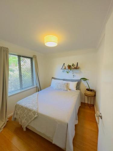a bedroom with a white bed and a window at All the comforts by the lake in Perth