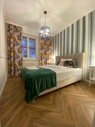 een slaapkamer met een groot bed en een groene deken bij Tabago Studio 18 in Opole